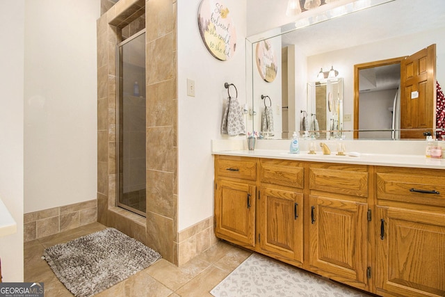 bathroom featuring tile patterned floors, a shower with door, and vanity