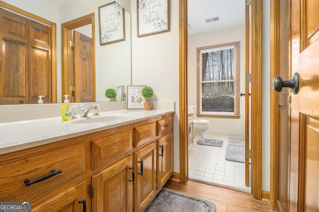 bathroom featuring vanity, hardwood / wood-style flooring, and toilet