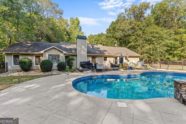 view of swimming pool featuring fence, a patio, and a fenced in pool