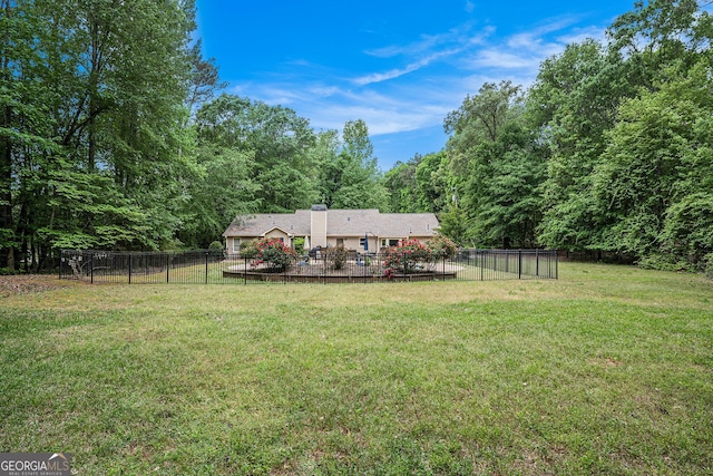 view of yard featuring a forest view, a patio, and fence