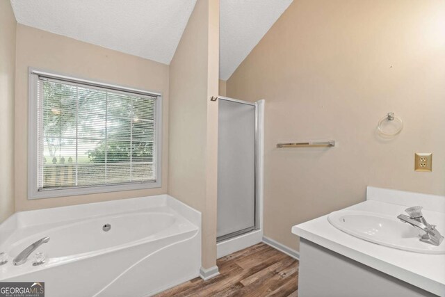 bathroom featuring wood-type flooring, vanity, independent shower and bath, and lofted ceiling