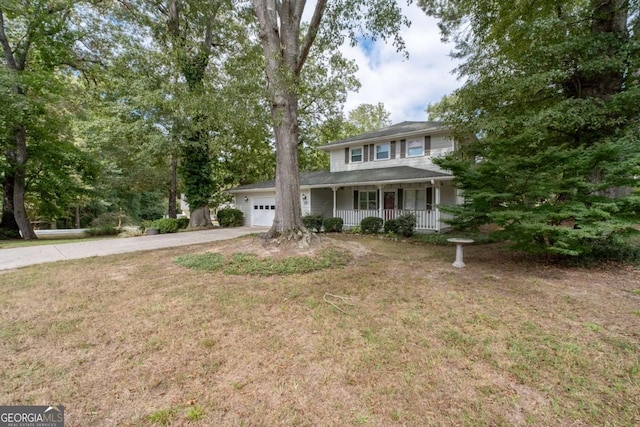 view of front of house with covered porch, a garage, and a front lawn