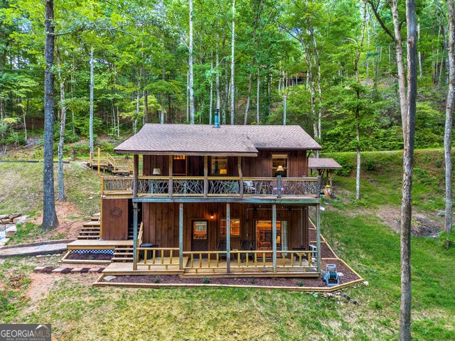 back of property featuring a yard and a wooden deck