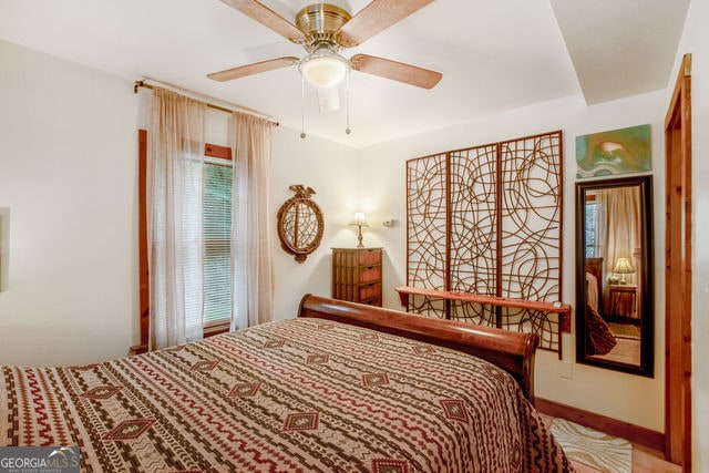 bedroom featuring multiple windows and ceiling fan