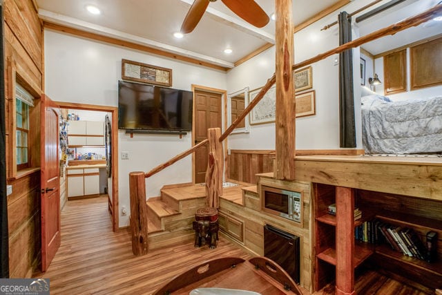 workout room with ceiling fan, crown molding, and hardwood / wood-style flooring