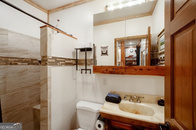 bathroom featuring vanity, toilet, and tiled shower