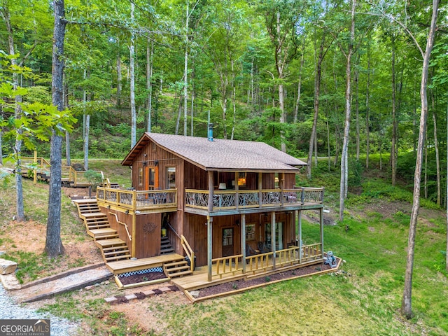 back of property featuring a lawn and a wooden deck