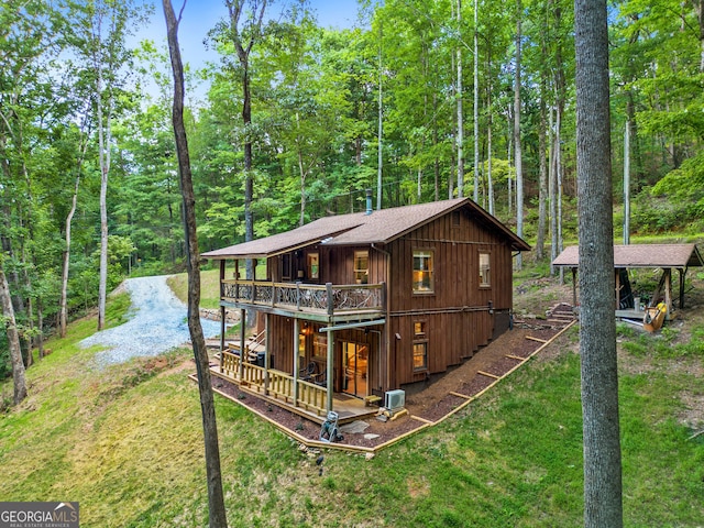 rear view of property featuring a deck and a lawn