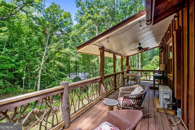 wooden terrace with ceiling fan and a porch