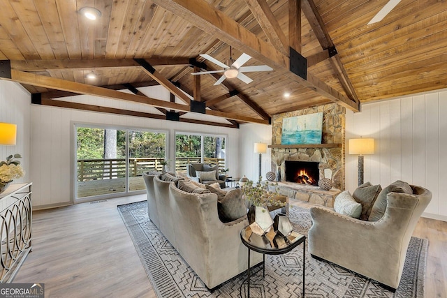 living room featuring ceiling fan, beamed ceiling, wood ceiling, and light wood-type flooring