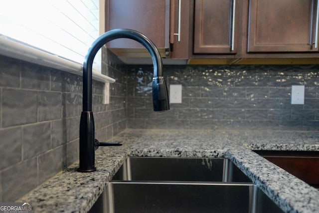 details with light stone counters, sink, and decorative backsplash