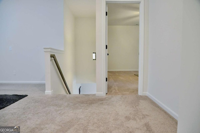 hall with light colored carpet