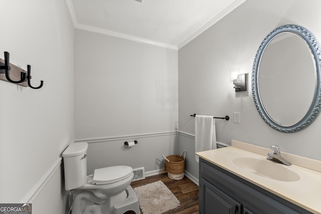 bathroom with crown molding, toilet, vanity, and hardwood / wood-style flooring