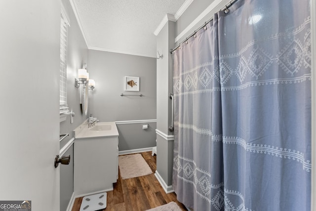 bathroom featuring ornamental molding, a textured ceiling, vanity, hardwood / wood-style flooring, and curtained shower