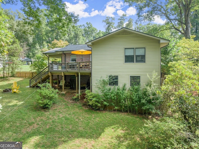 rear view of property featuring a lawn and a deck