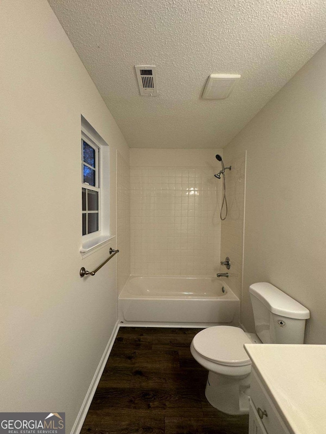 full bathroom featuring a textured ceiling, vanity, hardwood / wood-style flooring, and toilet