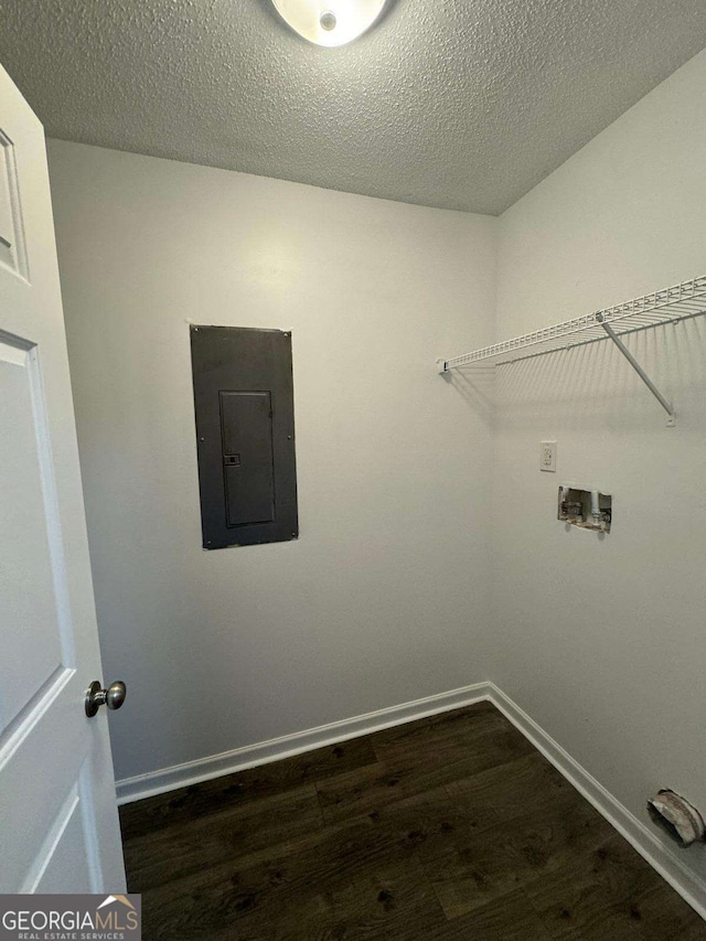 clothes washing area with washer hookup, a textured ceiling, electric panel, and dark wood-type flooring