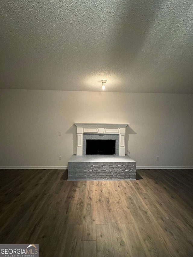 unfurnished living room with dark hardwood / wood-style floors and a textured ceiling