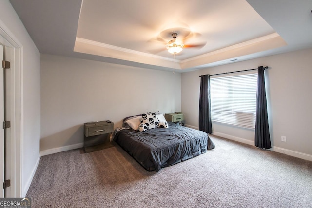 bedroom featuring carpet, ceiling fan, and a tray ceiling