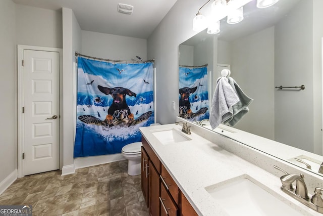 bathroom featuring a shower with shower curtain, vanity, and toilet