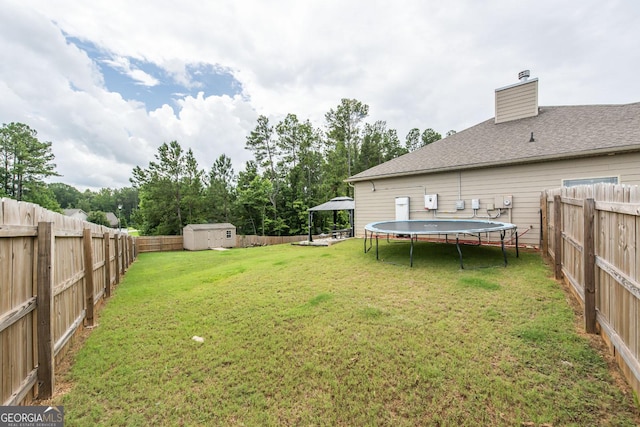 view of yard featuring a gazebo, a trampoline, and a storage shed