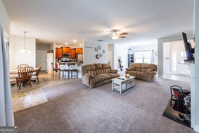 carpeted living room with ceiling fan