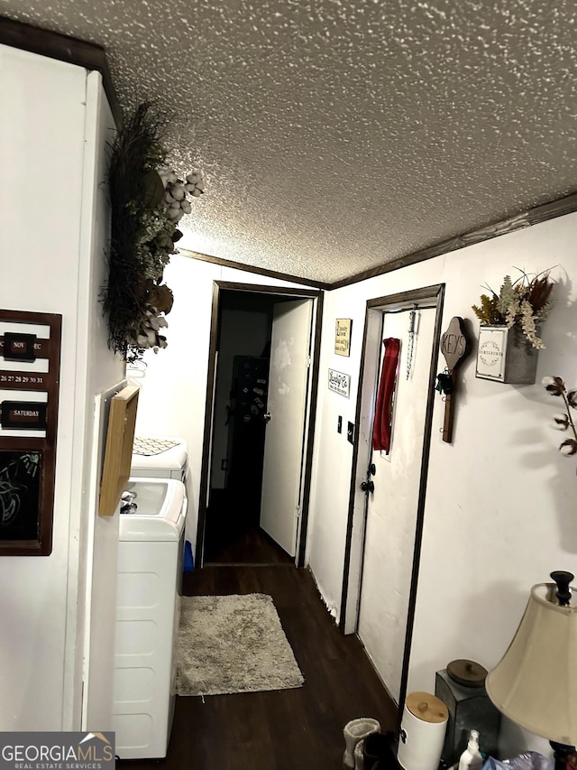 corridor featuring dark wood-type flooring, crown molding, and independent washer and dryer