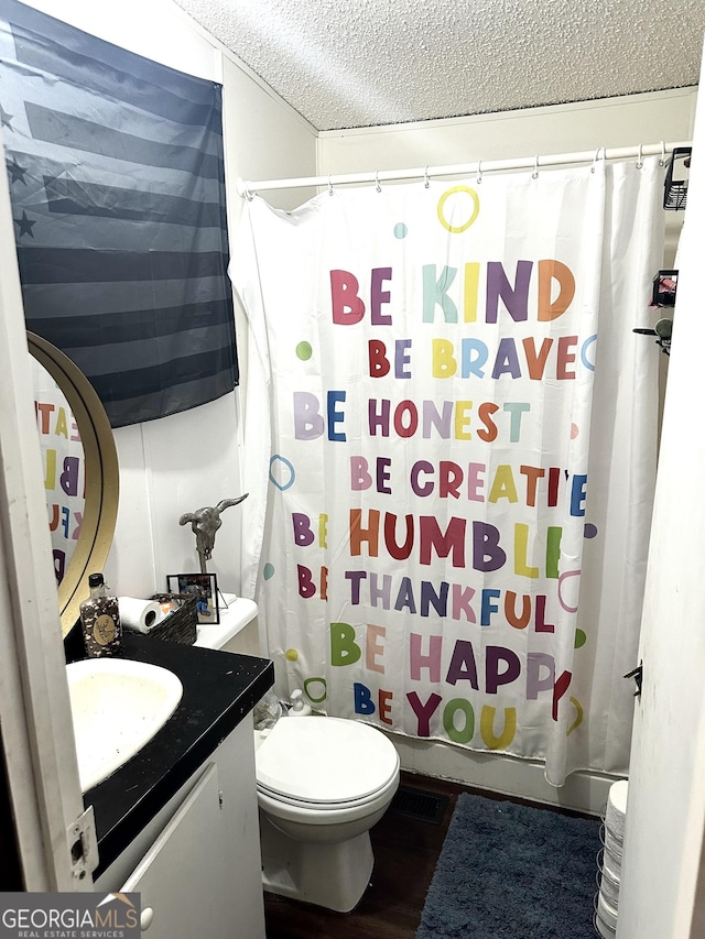 full bathroom featuring toilet, a textured ceiling, shower / bath combo, and vanity