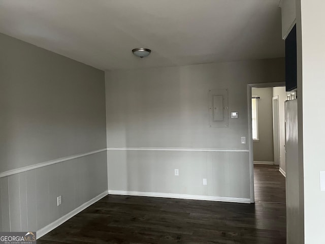 unfurnished room featuring dark wood-type flooring and electric panel