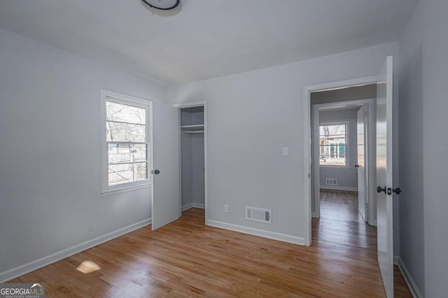 unfurnished bedroom with light hardwood / wood-style floors and a closet