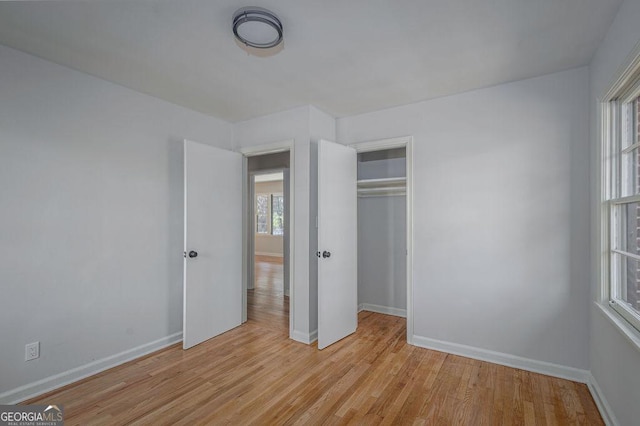 unfurnished bedroom featuring light wood-type flooring and a closet