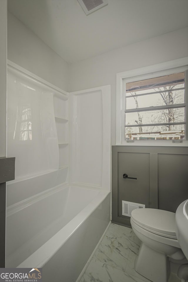 bathroom with washtub / shower combination and toilet