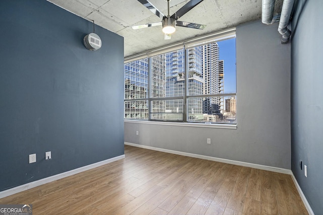 spare room with hardwood / wood-style flooring and ceiling fan