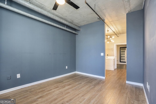 unfurnished room with washer / dryer, baseboards, a ceiling fan, and wood finished floors