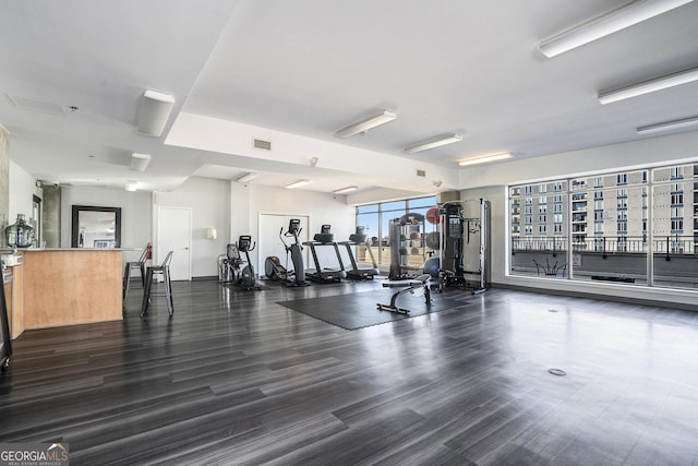 workout area with visible vents and dark wood-style flooring