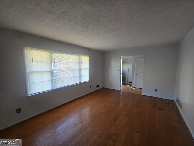 spare room with wood-type flooring and a textured ceiling