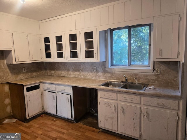 kitchen with white cabinetry, sink, a textured ceiling, and hardwood / wood-style flooring