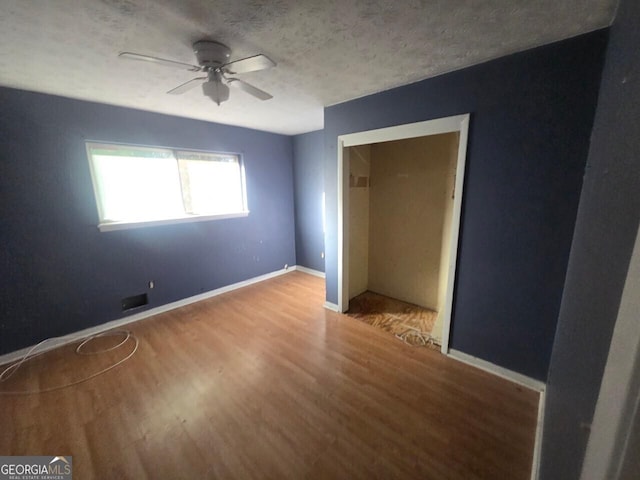 unfurnished bedroom featuring ceiling fan, light hardwood / wood-style floors, and a textured ceiling