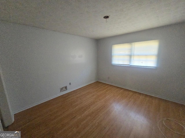 spare room with hardwood / wood-style floors