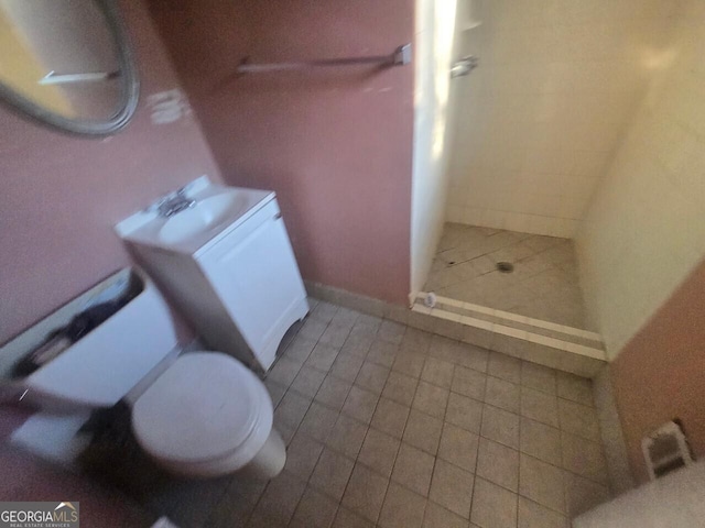 bathroom with toilet, vanity, tile patterned floors, and walk in shower