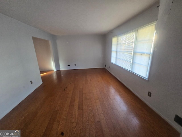 unfurnished room featuring dark wood-type flooring