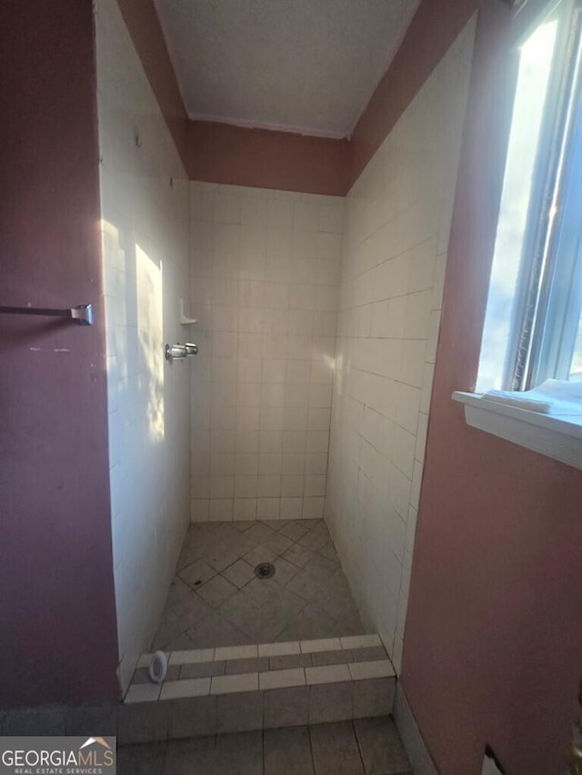 bathroom with a shower and tile patterned flooring