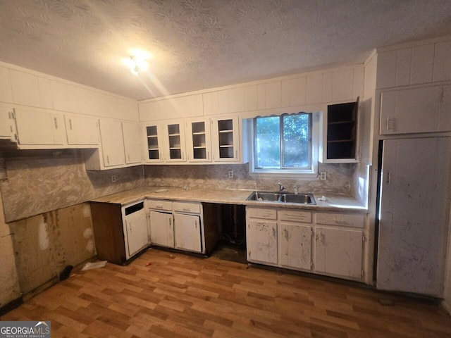 kitchen with white cabinetry, sink, hardwood / wood-style floors, and a textured ceiling