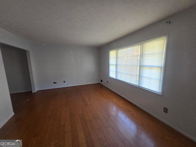 empty room with dark wood-type flooring