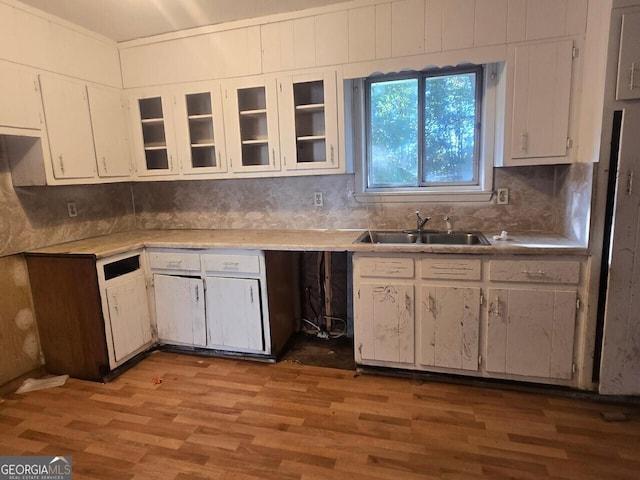 kitchen featuring white cabinets, backsplash, light hardwood / wood-style flooring, and sink