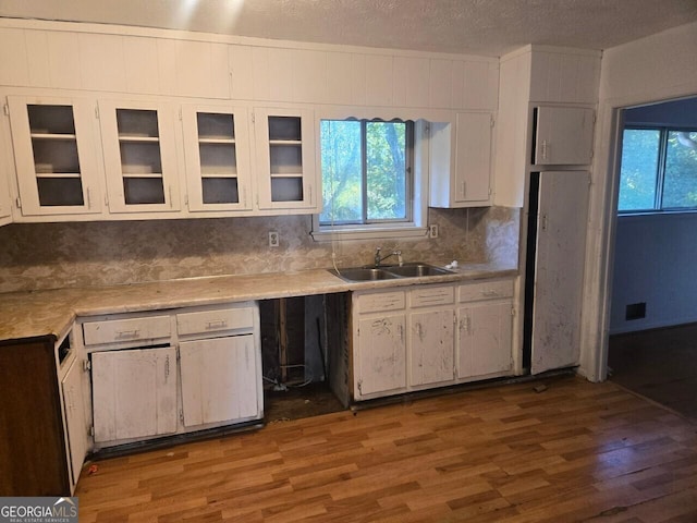 kitchen with white cabinets, a textured ceiling, sink, and dark wood-type flooring