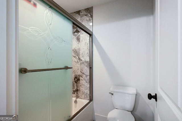 full bathroom featuring toilet and shower / bath combination with glass door