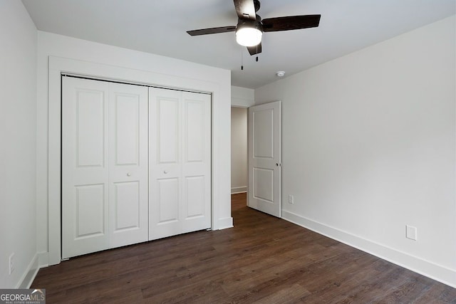 unfurnished bedroom featuring a closet, dark wood-style flooring, baseboards, and a ceiling fan