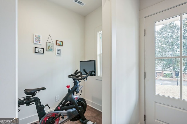 workout area with visible vents and dark wood-type flooring