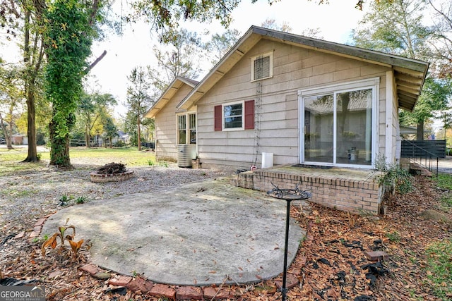 rear view of house featuring a fire pit and a patio